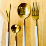 Gold-colored knife, fork, spoon, and teaspoon set.